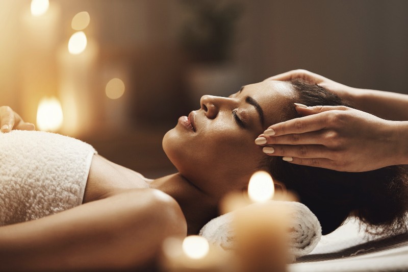 attractive-african-woman-enjoying-face-massage-in-spa-salon